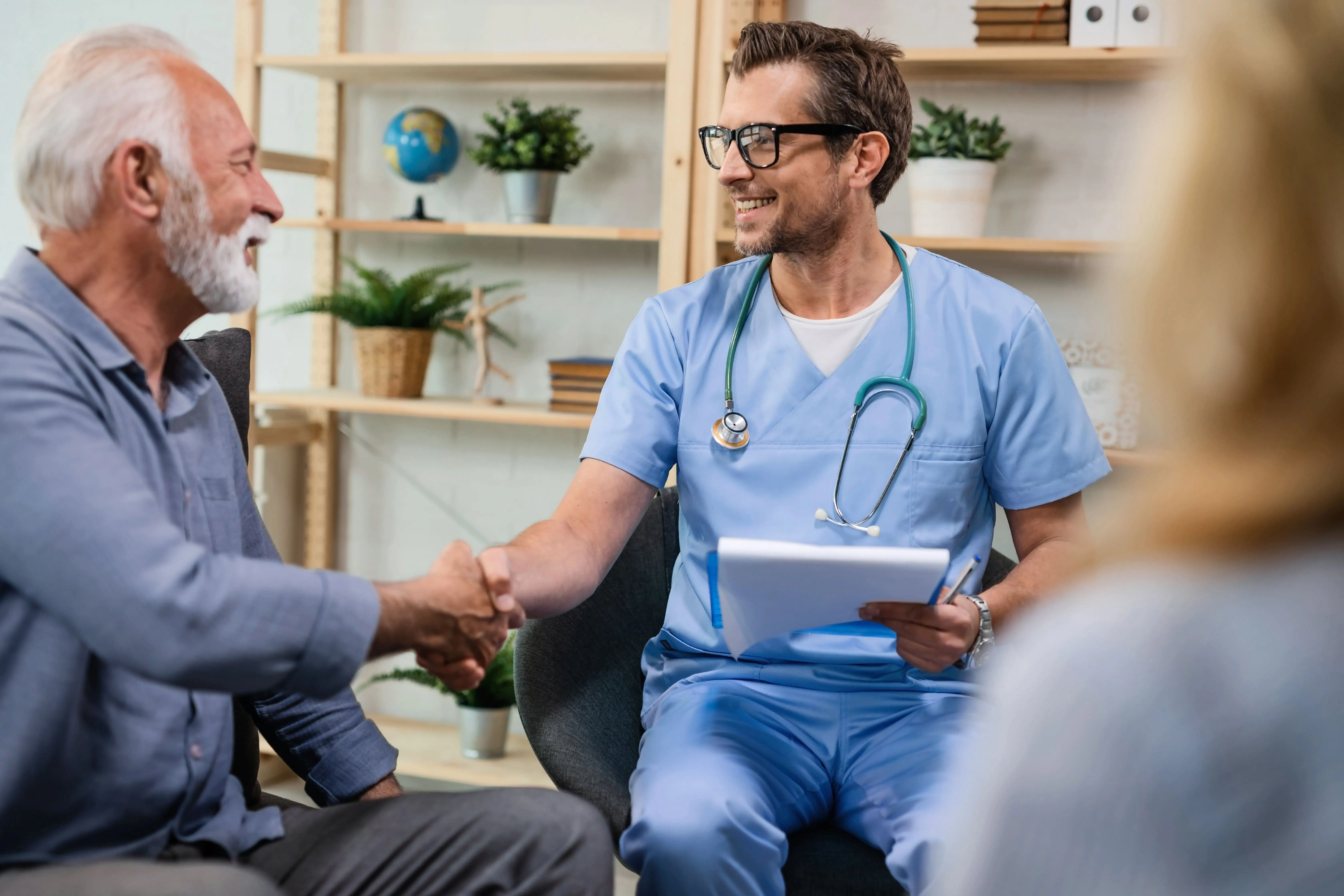 Healthcare worker shaking hands with senior patient